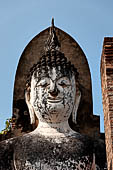 Thailand, Old Sukhothai - Wat Mahathat, detail of the statue of standing Buddha enshrined in a mandapa on the side of the main chedi. 